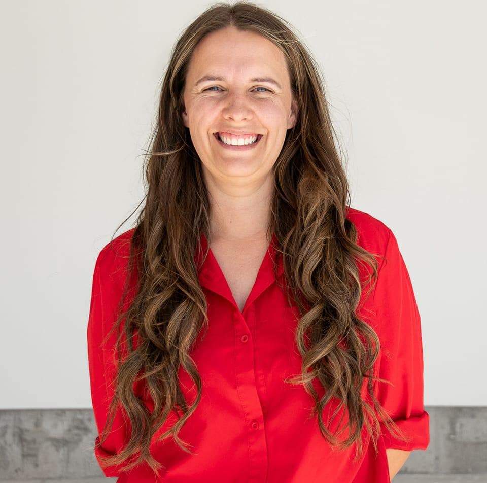 Image of Becca Summers, smiling in a red shirt